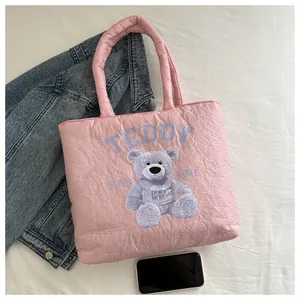 Detailed shot of pink quilted puffy tote bag featuring cute teddy bear graphic and thick handles