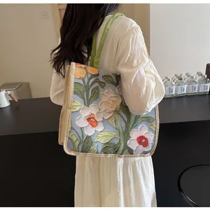 Détail du motif floral en relief sur le sac fourre-tout en toile bleue