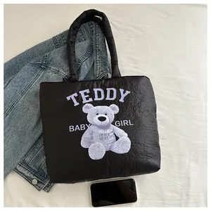 Detail of black quilted tote bag with purple teddy print and hello new here text
