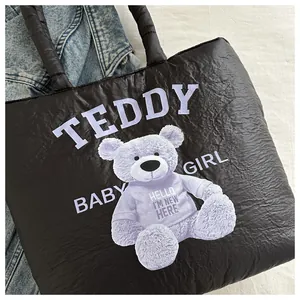 Detail view of quilted black tote bag featuring a cute purple teddy bear print and text