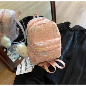 Detail of pink mini backpack featuring colorful embroidery and a plush cloud charm