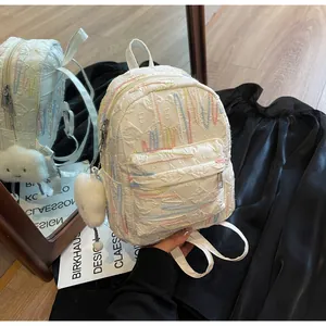 Detail of white mini backpack with colorful embroidery texture and cloud charm
