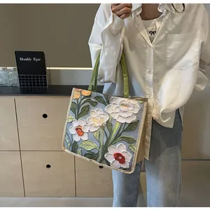 Détail du cabas montrant des motifs floraux en relief et une poignée en tissu olive