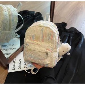 Detail of white mini backpack with wave embroidery, embossed fabric, and cloud charm