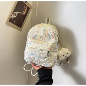 Detail of white textured mini backpack with multi-colored stitching and plush cloud charm