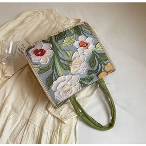 Détail de la broderie florale 3D et texture lin sur ce sac fourre-tout bleu