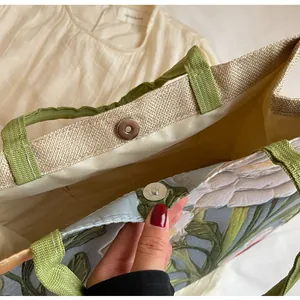 Détail du sac cabas ethnique à fleurs montrant la boucle magnétique et les anses vertes