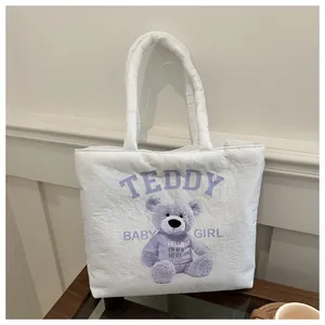 Detailed view of a white quilted tote bag featuring a cute purple teddy bear print