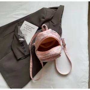Close-up of pink mini backpack featuring 3D embossed fabric texture and zipper details