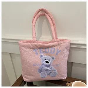 Detailed view of pink quilted nylon tote bag with purple teddy bear and Teddy text