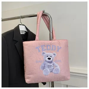 Close-up of pink quilted puffer tote bag with cute purple teddy bear print details