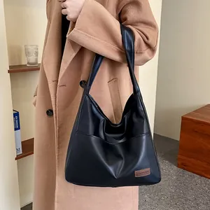Minimalist black PU leather tote bag with large capacity and soft vintage texture on model
