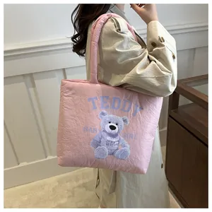 Close-up of pink quilted teddy bear tote bag showing soft texture and artistic prints