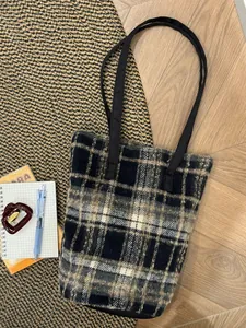 Gros plan du sac cabas en laine à carreaux noir et gris avec poignées renforcées