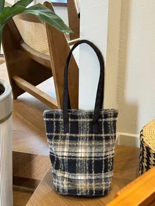Vue détaillée du motif à carreaux classique et de la texture en laine de ce sac cabas