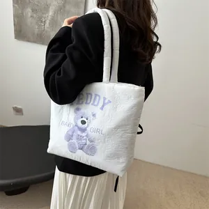 White quilted tote bag with cute purple teddy bear print worn by model on shoulder