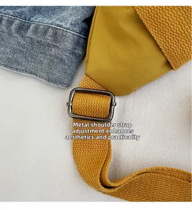 Detail of adjustable metal buckle and woven strap on ginger yellow canvas sling bag