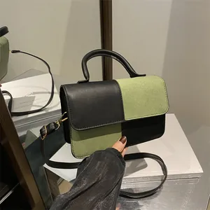 Chic black and green checkered crossbody bag with round handle and gold hardware detail