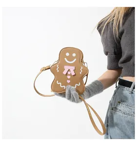 Détail du sac bandoulière bonhomme en pain d'épices avec des nœuds roses décoratifs