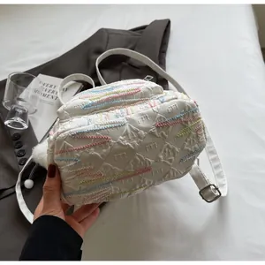 Detail of white quilted backpack with colorful wave embroidery and adjustable straps