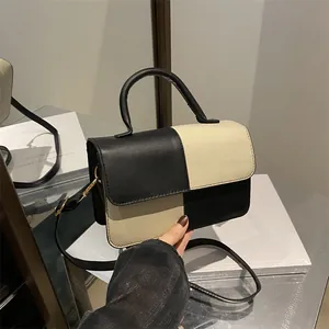 Chic black and beige checkered shoulder bag with gold hardware and top handle