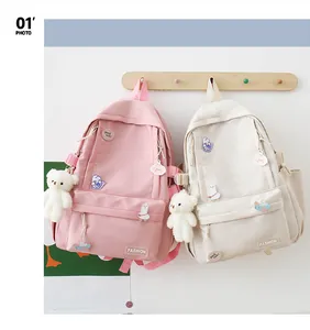 Dettaglio di zaini rosa e beige con simpatici distintivi e ciondolo a forma di orso