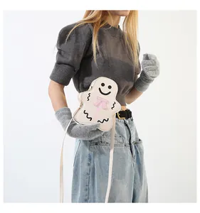 Détail du sac bandoulière bonhomme de pain d'épices blanc avec nœud rose sur tricot