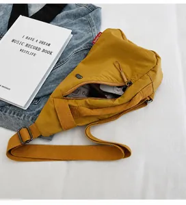 Detailed view of yellow canvas chest bag with adjustable strap and spacious inner storage