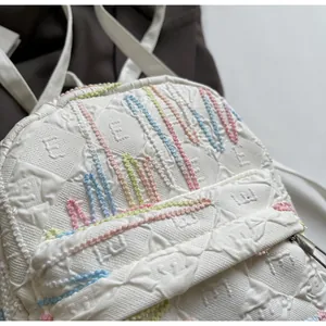 Detail of white quilted backpack with colorful 3D wavy lines and textured fabric