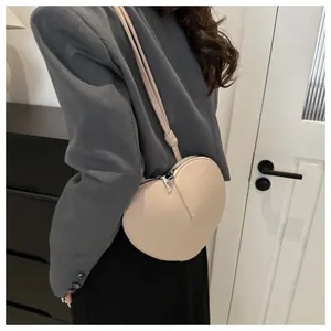 Beige herzförmige PU-Leder Umhängetasche kombiniert mit einem graublauen Blazer für Frauen