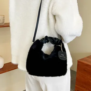 Sac bandoulière chic en fausse fourrure noire avec pendentif et poignée en cuir élégante