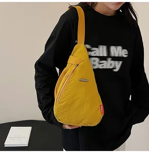 Close-up of yellow waterproof nylon chest bag featuring adjustable strap and metal logo