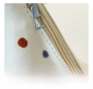 Detailaufnahme des glatten Silberreißverschlusses und Tupfenstoffs der Tragetasche