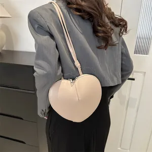 Schicke beige herzförmige Umhängetasche für Damen mit glattem Lederfinish und Silber-Reißverschluss