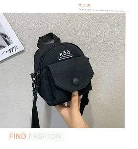 Detail of black canvas crossbody bag featuring white KŎQ logo and durable zipper pocket
