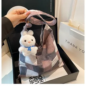 Dettaglio borsa tote in tela patchwork geometrica con un grazioso ciondolo a coniglio