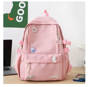 Dettaglio di uno zainetto rosa con badge alla moda e fibbie laterali su una scrivania