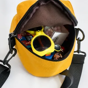 Top view of bright yellow canvas crossbody bag showing interior capacity and zipper