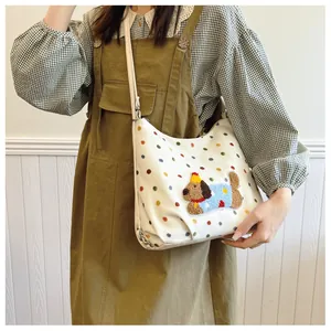 Nahaufnahme einer weißen Canvas-Tasche mit bunten Punkten und 3D-Plüsch-Welpen-Patch