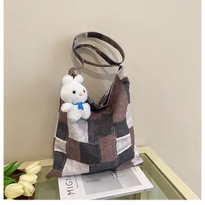 Dettaglio della borsa tote in tela patchwork con ciondolo a forma di coniglio