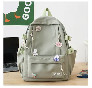 Dettaglio zaino verde chiaro con distintivi a cartoni animati ed etichetta moda