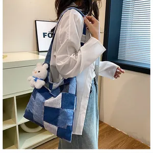 Dettaglio borsa tote in denim patchwork con ciondolo a forma di coniglio peluche