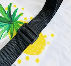 Detail of black woven crossbody bag strap featuring a durable plastic adjustable buckle