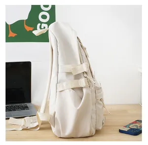 Detalle lateral de mochila crema con bolsillo y correas ajustables de calidad
