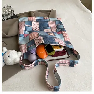 Vista dall'alto della capiente borsa tote a quadri con ombrello e tablet all'interno