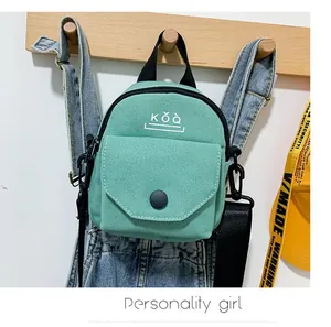 Detail of mint green canvas crossbody bag with KǑQ lettering and adjustable strap