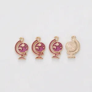 Detail of pink enamel globe pendant with golden alloy finish and radiant metal texture
