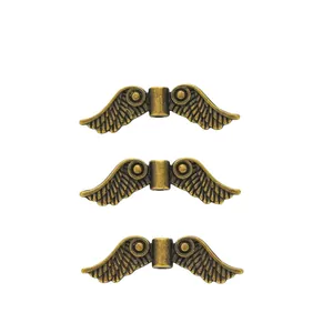 Macro shot of three vintage bronze wing beads with detailed feather texture for DIY jewelry