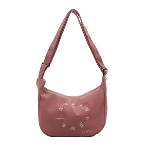 Pink corduroy crescent crossbody bag with embroidery and adjustable shoulder strap