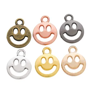 Detalle de colgantes vintage de cara sonriente en seis colores metálicos para joyería DIY